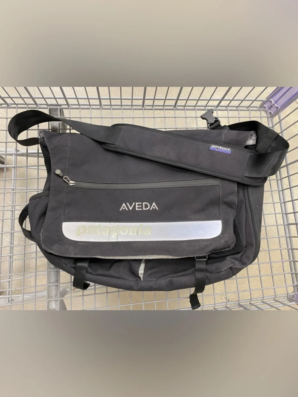 Patagonia 'Critical mass' messenger bag in black - AVEDA logo embroidered